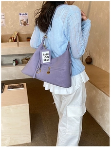 Détail du sac à bandoulière hobo violet avec texture cuir mat et fermeture éclair dorée