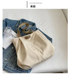 Off-white nylon tote bag with brown handles, styled with a denim jacket and lifestyle props