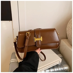 Detail of vintage brown leather bag showing gold buckle and high-quality textured finish