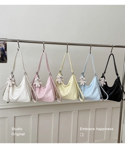 Detail view of colorful soft leather hobo bags in five colors with plush bear charms