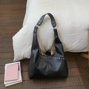 Detail der schwarzen Hobo-Tasche aus Kunstleder mit silbernen Ösen und Ziernieten