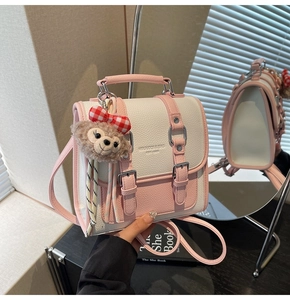 Detail of pink and white textured leather small square bag with cute plush charm