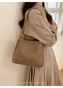 Detail of vintage brown tote bag showing textured leather finish and gold logo plate