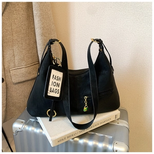 Détail du sac sous le bras en cuir noir avec garnitures dorées et étiquette mode