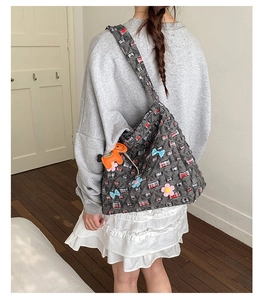 Dettaglio della borsa tote in tweed grigio con fiori 3D e ciondolo a cavallo