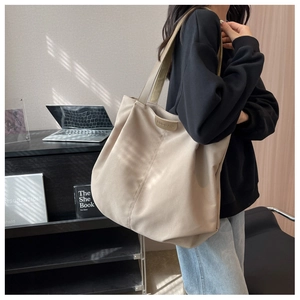 Close-up of beige nylon tote bag with pleated design and leather BUDBAO logo patch