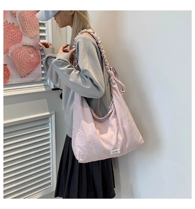 Close-up of pink canvas tote bag with star patterns and elastic ruched shoulder strap