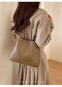 Détail du sac cabas en cuir froissé marron café avec plaque métal sur modèle