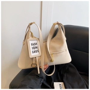 Détail du sac à bandoulière crème avec poche zippée dorée et porte-carte de mode