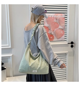 Detail of mint green canvas tote bag with ruched strap and silver star accents