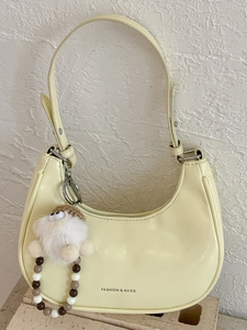 Minimalistische cremefarbene Handtasche mit verstellbarem Riemen und Plüschtier-Anhänger