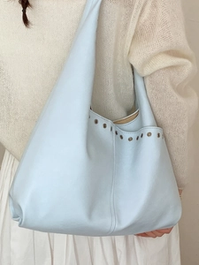 Hellblaue Shopper-Tasche aus Kunstleder mit modischen Metallösen und weicher Beutelform