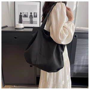 Black canvas tote bag for women showing large capacity and comfortable wide shoulder strap