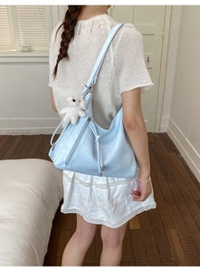 Light blue faux leather hobo bag with teddy bear charm and side zipper detail