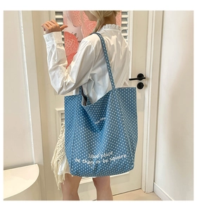 Detail einer blauen Canvas-Tasche mit weißen Punkten und künstlerischem Fun-Party-Schriftzug