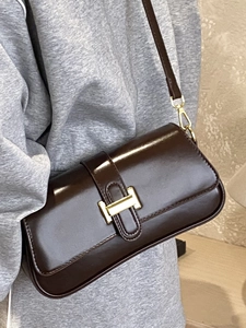 Glossy coffee baguette shoulder bag with gold H-shaped buckle in a minimalist chic style