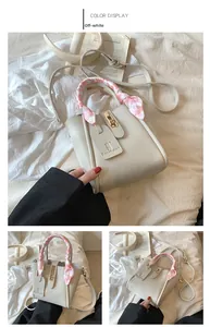 Dettaglio borsa a secchiello in pelle crema con grana litchi e foulard in seta decorativo