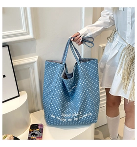 Detailaufnahme der Jeansblauen Polka-Dot-Tasche mit weißem Kunsttext und Canvas-Material