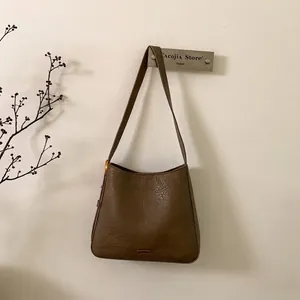 Detail shot of vintage brown synthetic leather tote bag with crinkle texture and metal bar