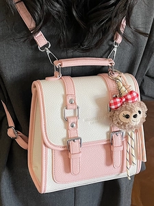 Chic pink and beige square crossbody bag with ShellieMay charm worn by model
