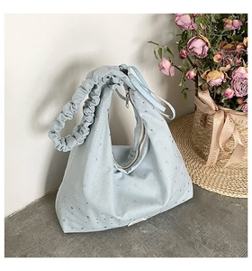 Detail of light blue polka dot canvas tote with silver star prints and pleated strap