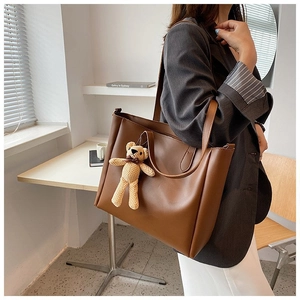 Brown large capacity tote bag detail with cute knitted bear charm on shoulder strap