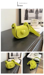 Close-up of a green heart-shaped mini saddle bag with PU leather and side detail view