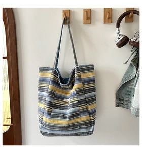 Detail der bunt gestreiften Canvas-Tragetasche mit Vordertasche und gewebter Textur