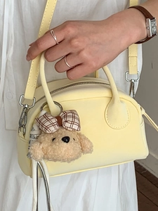 Fashionable pale yellow Boston bowling bag with a cute bear charm for women 2026