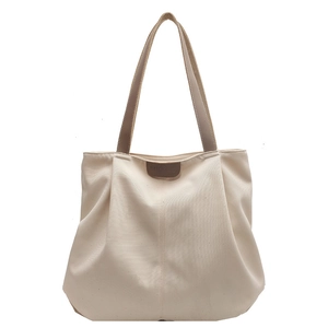 Minimalist beige canvas tote bag with brown leather straps and branded logo tag