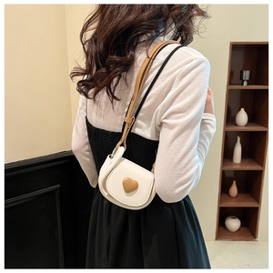 Rear view of a girl wearing a white mini crossbody bag with a brown heart detail
