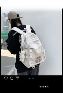 Detail view of cream white backpack with mesh pockets and cute plush bear keychain
