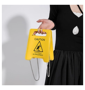 Détail du sac à main créatif jaune en forme de panneau de signalisation avec chaîne à billes