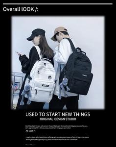 Detail view of large capacity nylon backpack in black and white with doll pendant