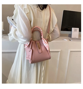 Borsa a secchiello rosa in pelle con foulard di seta e tracolla in interni chic