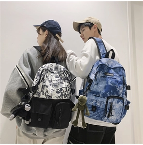 Detail of Korean style student backpacks with graffiti and tie-dye patterns and plush charms