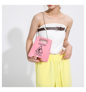 Vue détaillée du sac à main rose en forme de panneau de signalisation avec chaîne argentée