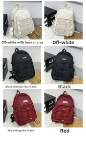 Three large capacity school backpacks in off-white, black, and red with bungee cord detail