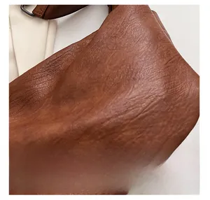 Macro shot of high-quality brown leather texture and stitching on large tote bag
