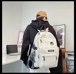Detailed back view of a white large capacity backpack with KDMILD logo and frog pendant