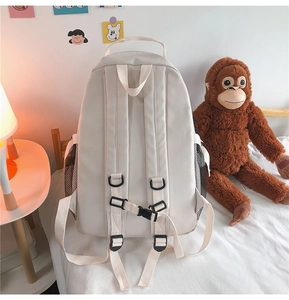 Detail of ergonomic padded shoulder straps and chest buckle on large beige backpack