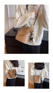 Beige lychee texture bucket bag with woven handle, metal chain and cute rabbit charm