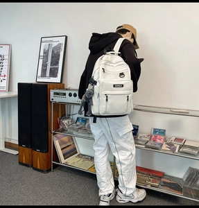 White multi-pocket backpack with aesthetic gibbon doll charm for students and commuting