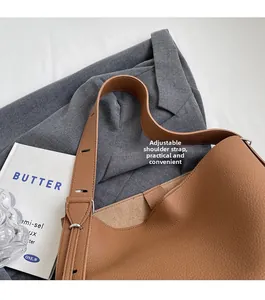 Détail du sac cabas en cuir marron grainé avec une large bandoulière réglable pratique