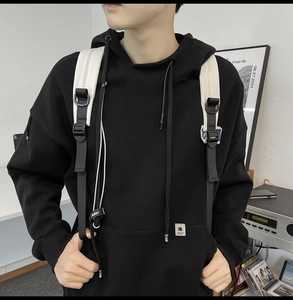 Detail view of heavy cotton oversized black hoodie with white contrast drawstrings and tags