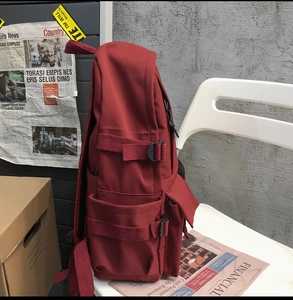 Detail view of the dark red student backpack side buckles and durable side pocket