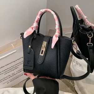 Elegante borsa a secchiello in pelle nera con manico in seta e dettagli in metallo dorato