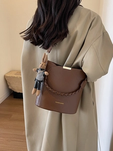 Women's dark brown leather bucket bag with woven handle and plush bunny charm