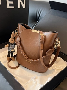Fashionable brown bucket bag with woven strap and rabbit charm in premium gift box