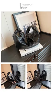 Detailed view of the soft black faux leather texture and metallic strap buckle on the hobo bag